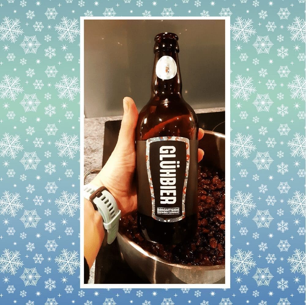 Brightside brewing Gluhbier 4.5% 500ml bottle held in a ladies with teal garmin watch hand ready to be used to mix with raisins
